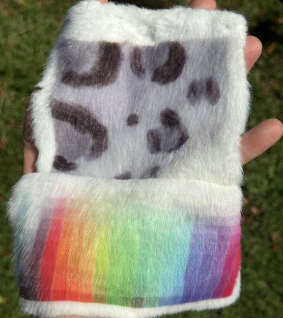 Two swatches of white polymink, one dye sublimated with snow leopard rosettes and the other with a rainbow color palette