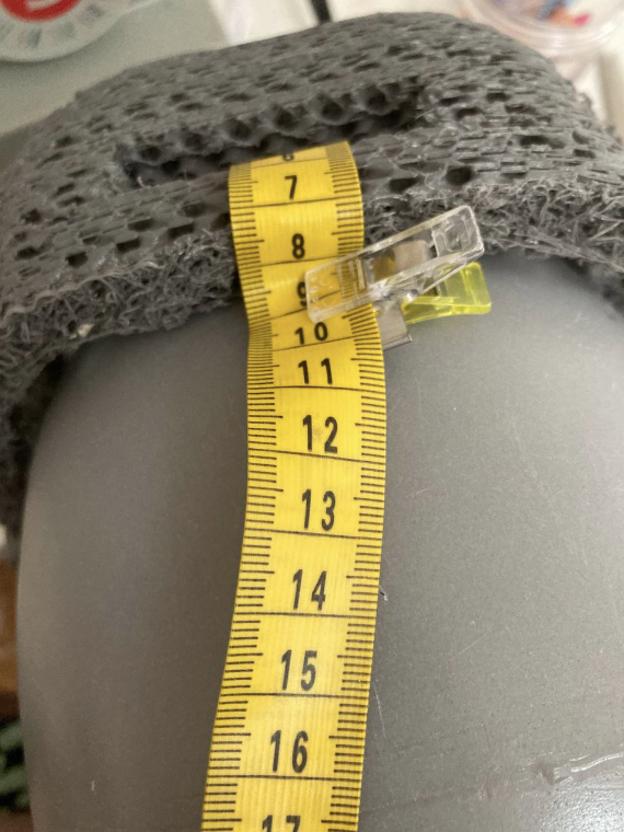 Measuring tape looping around one of the straps on the headbase, being held by a clip