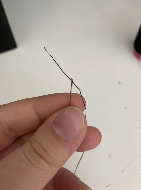 Close up of a needle with some thread through it