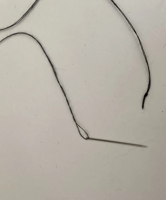 Thread with needle and a knot at the end