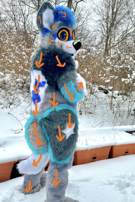 Full fursuit in the snow with orange arrows marking fur direction