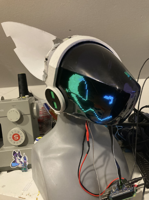 A happy protogen with an electronic face, visor, and one ear attached