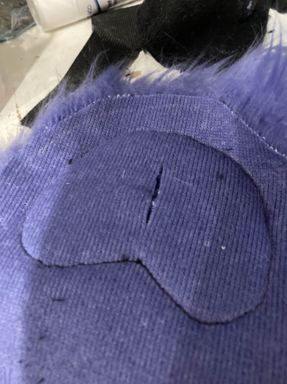 Slit in fur backing for paw pad