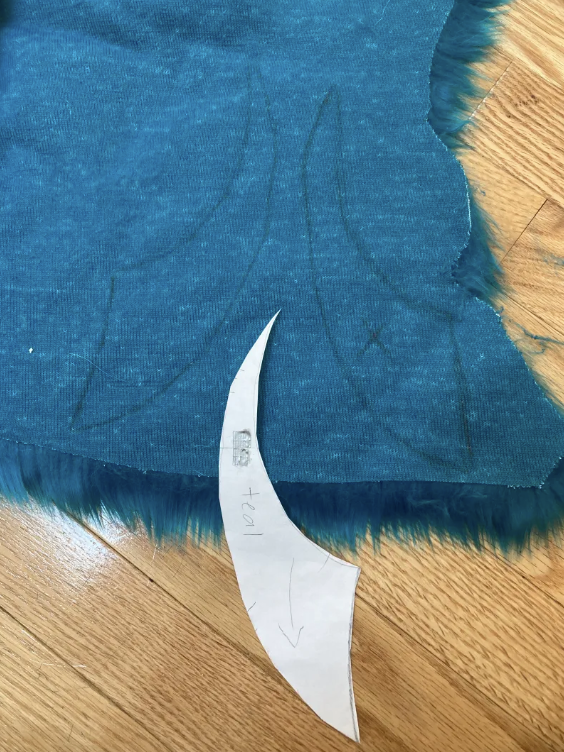 A marking pattern piece traced onto teal faux fur twice